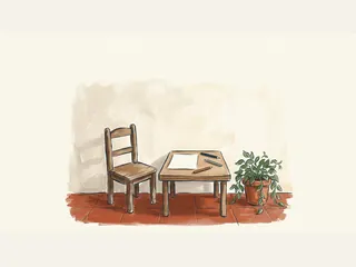 Una silla infantil vacía junto a una mesa con papel en blanco y tres lápices.