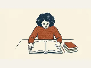 Persona leyendo un libro abierto junto a dos libros cerrados sobre una mesa.