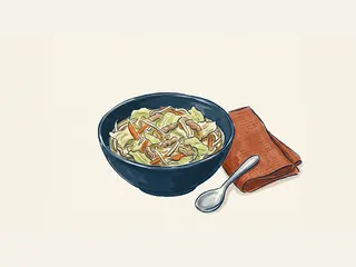 Cuenco de chop suey con carne, col, zanahoria y brotes, junto a una cuchara.