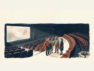 Cuatro adultos conversan en el pasillo de una sala de cine entre filas de butacas y una pantalla iluminada.