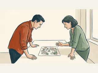 Dos personas observan un dibujo de una plaza mediterránea imaginaria sobre una mesa.
