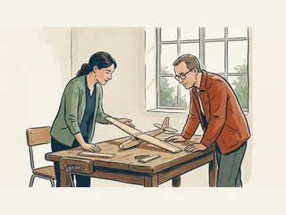 Dos personas observan una maqueta genérica de planeador de madera sobre una mesa.