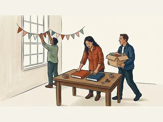 Tres personas preparan una sala para un encuentro, con banderines de colores, una caja y dos cuadernos cerrados.