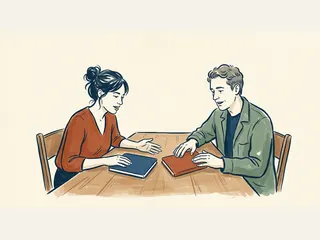 Dos personas comparan cuadernos cerrados sobre una mesa.