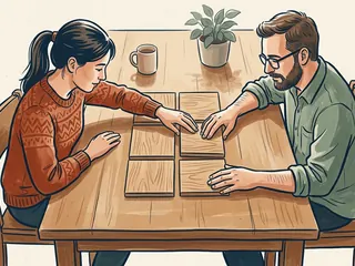 Dos personas ordenan seis piezas cuadradas de madera en una mesa.