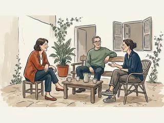 Tres adultos sonríen mientras conversan alrededor de una mesa en un patio.