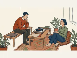 Dos personas adultas comparten un momento de escucha junto a un tocadiscos y carpetas lisas.