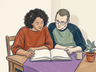 Dos personas adultas observan un libro abierto de páginas vacías sobre una tela morada.