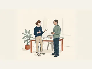 Dos profesionales conversan junto a una mesa con un cuaderno cerrado