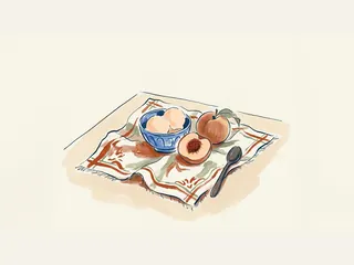 Cuenco con helado de melocotón, fruta entera y una mitad con hueso sobre un paño.