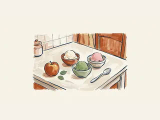 Tres cuencos de helado de distintos colores con una manzana y una cuchara en una cocina doméstica.