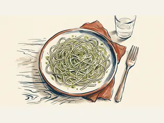Un plato de linguini con pesto junto a un tenedor y un vaso de agua.