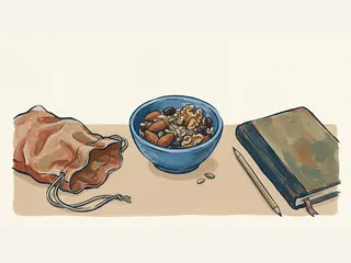 Cuenco de frutos secos y semillas junto a una bolsa de tela y un cuaderno.