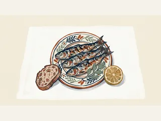 Tres sardinas sobre un plato de cerámica, junto a una rodaja de limón y una rebanada de pan.